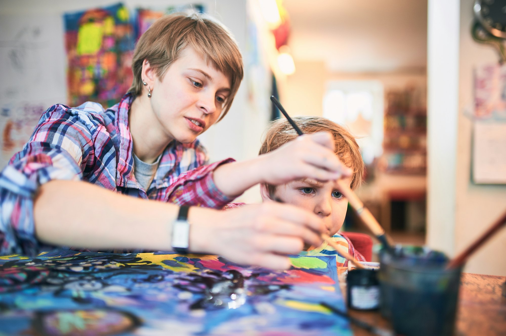 Cute happy little boy and teacher drawing in artist class