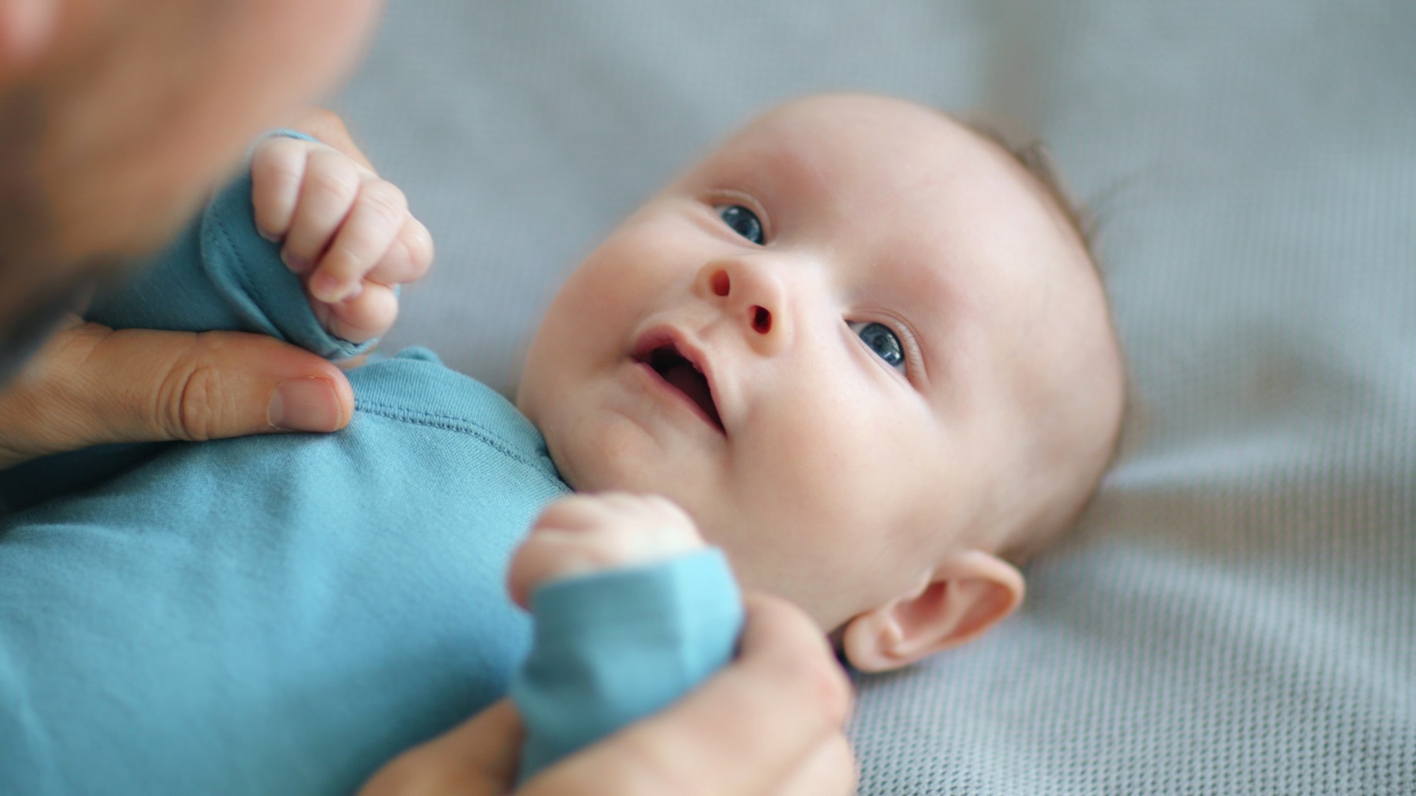 Dad playing with a newborn baby. Cute baby is trying to pronounce sounds while looking at his dad.